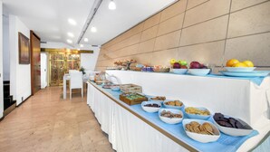 Montaje de bufé con diferentes opciones de comida y un comedor con sillas y una mesa.