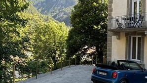 Rakennus, jonka edessä on sorapäällysteinen ajotie ja parkissa olevia autoja.