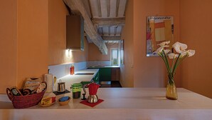 A kitchen with a wooden ceiling, a sink, and a vase with flowers on the counter. - La Foresteria Castell'In Villa (Castelnuovo Berardenga)