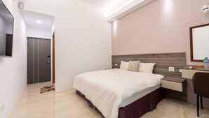 A modern hotel room with a large bed, a desk, and a TV mounted on the wall. - New One Villa (Hengchun)