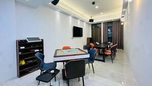 A modern conference room with a large table, chairs, a projector, and a TV on the wall. - New One Villa (Hengchun)