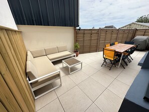 Relax on the patio with a comfortable sofa, dining table, and chairs.