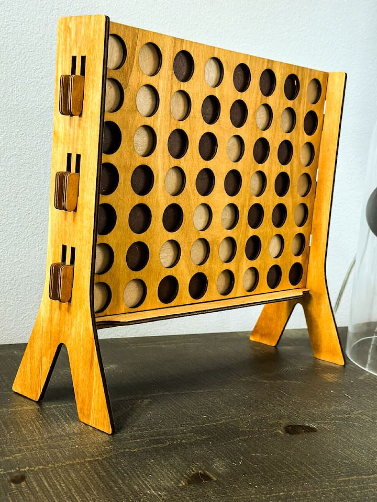 Un supporto in legno con diversi fori circolari, probabilmente per contenere oggetti.