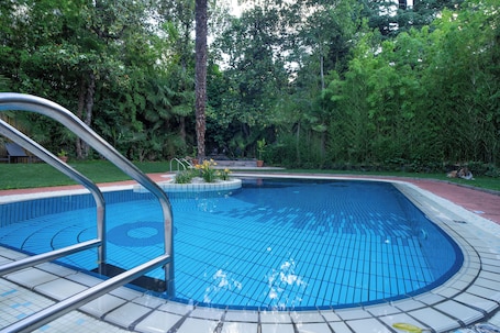 Una piscina al aire libre de temporada, sombrillas