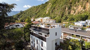 Un edificio moderno con varios pisos, balcones y una terraza en la azotea.