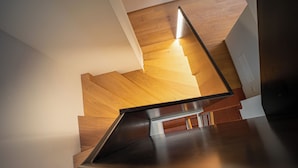Una escalera moderna con escalones de madera y barandilla de metal.