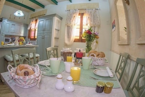 Enjoy a traditional breakfast in this charming room, complete with a dining table set for two and a fully equipped kitchen.