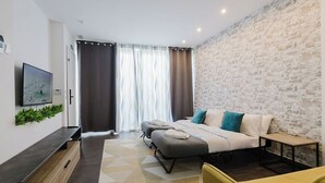 Een moderne slaapkamer met een bed, een televisie en een stenen muur.