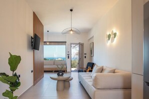 Ein modernes Wohnzimmer mit einer Couch, einem Couchtisch und einem an der Wand befestigten Fernseher.