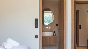 Un baño moderno con lavamanos independiente, espejo y tocador de madera.