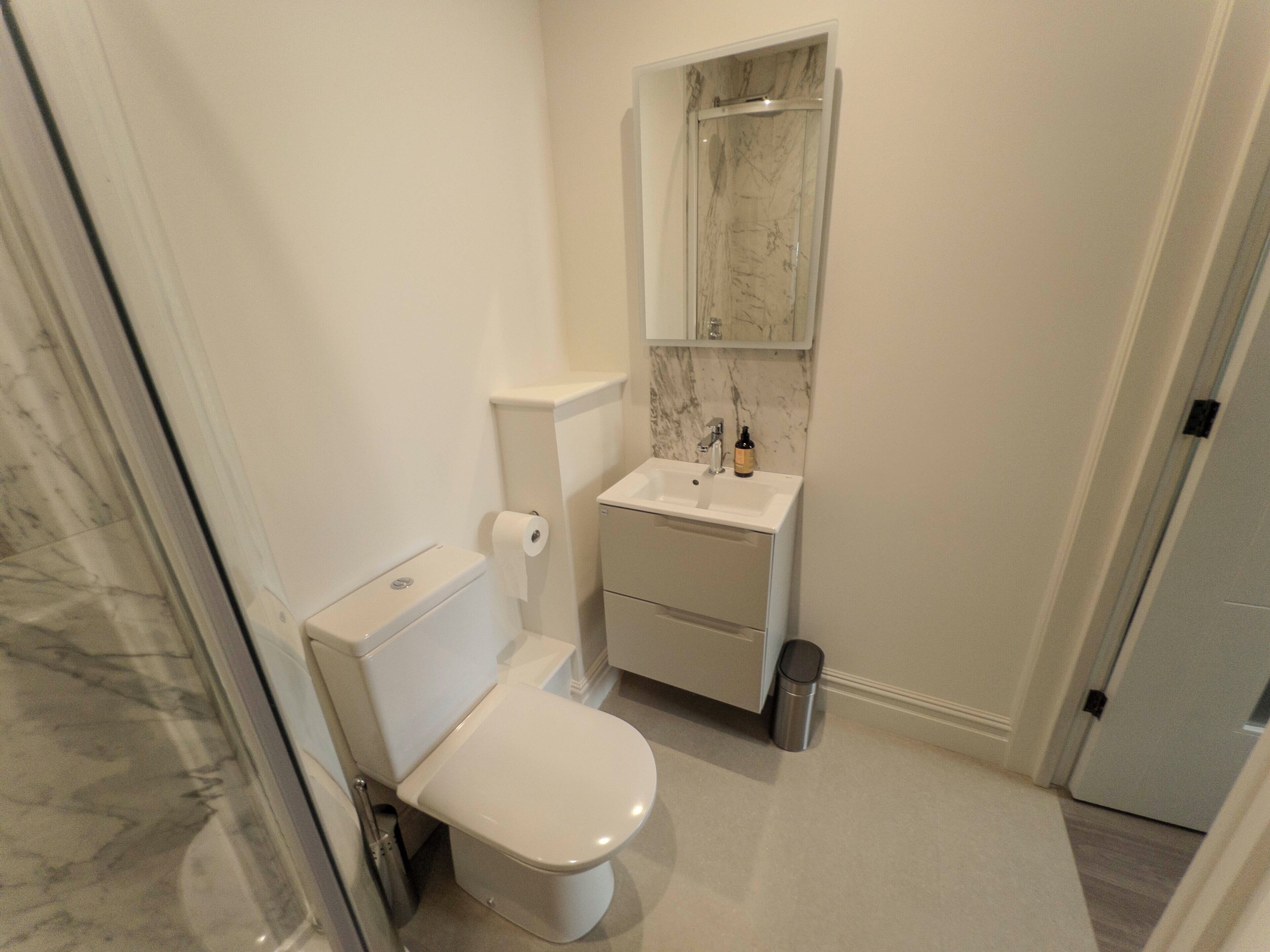 Une petite salle de bain comprenant des toilettes, un lavabo et un miroir.