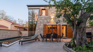 A modern house with a stone exterior, a patio with a pool, and a dining area. - Villa Giulia Zadarvillas (Privlaka)