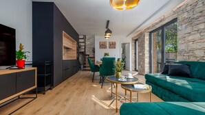 A modern living room with a green sofa, wooden flooring, and a staircase leading to an upper level. - Villa Giulia Zadarvillas (Privlaka)