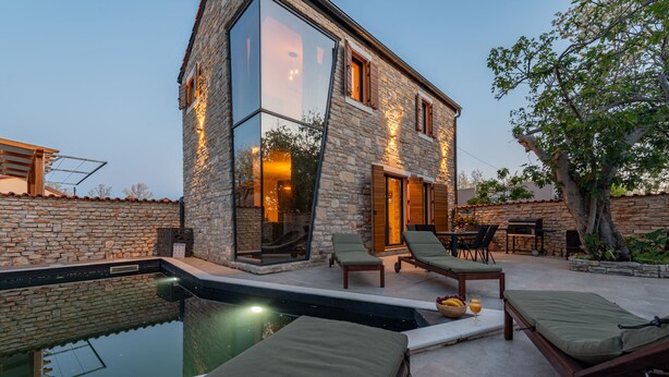 A modern stone building with a swimming pool, lounge chairs, and a dining area. - Villa Giulia Zadarvillas (Privlaka)