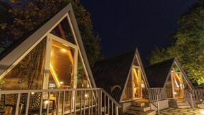 Una fila di cabine con tetti a punta, porte in vetro e un molo di legno.
