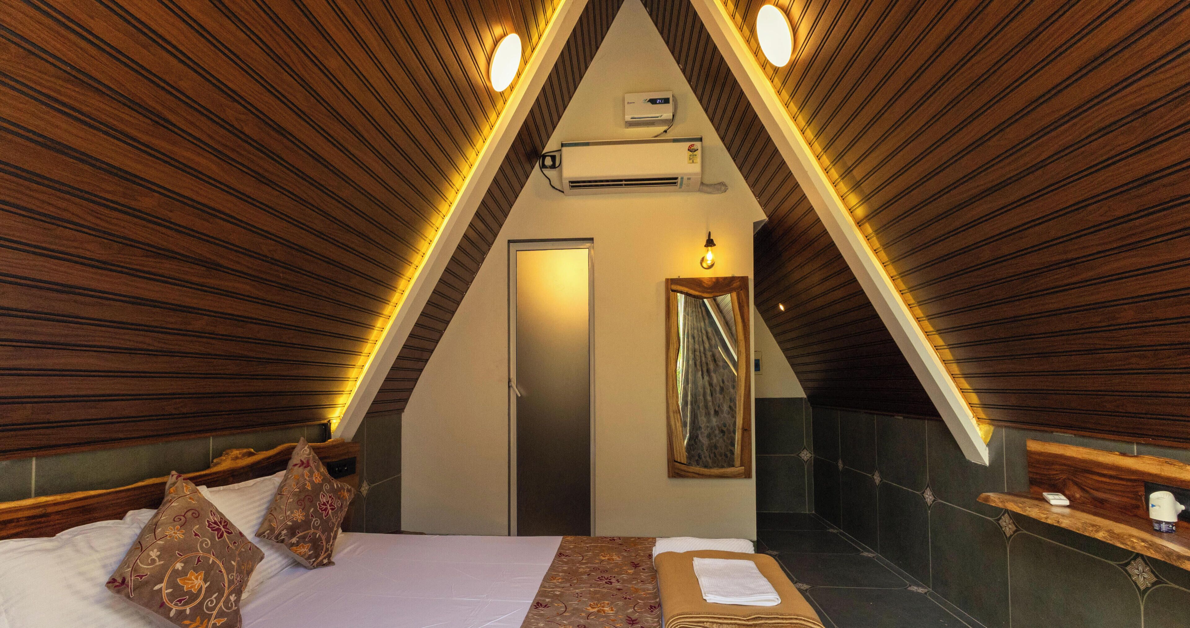Une pièce triangulaire comprenant un lit, un miroir et un appareil de climatisation.