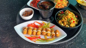 Un tavolo imbandito con diversi piatti, tra cui una porzione di fritture, un'insalata e una zuppa.
