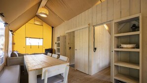 A cozy, wooden interior with a dining table, benches, and built-in shelves.