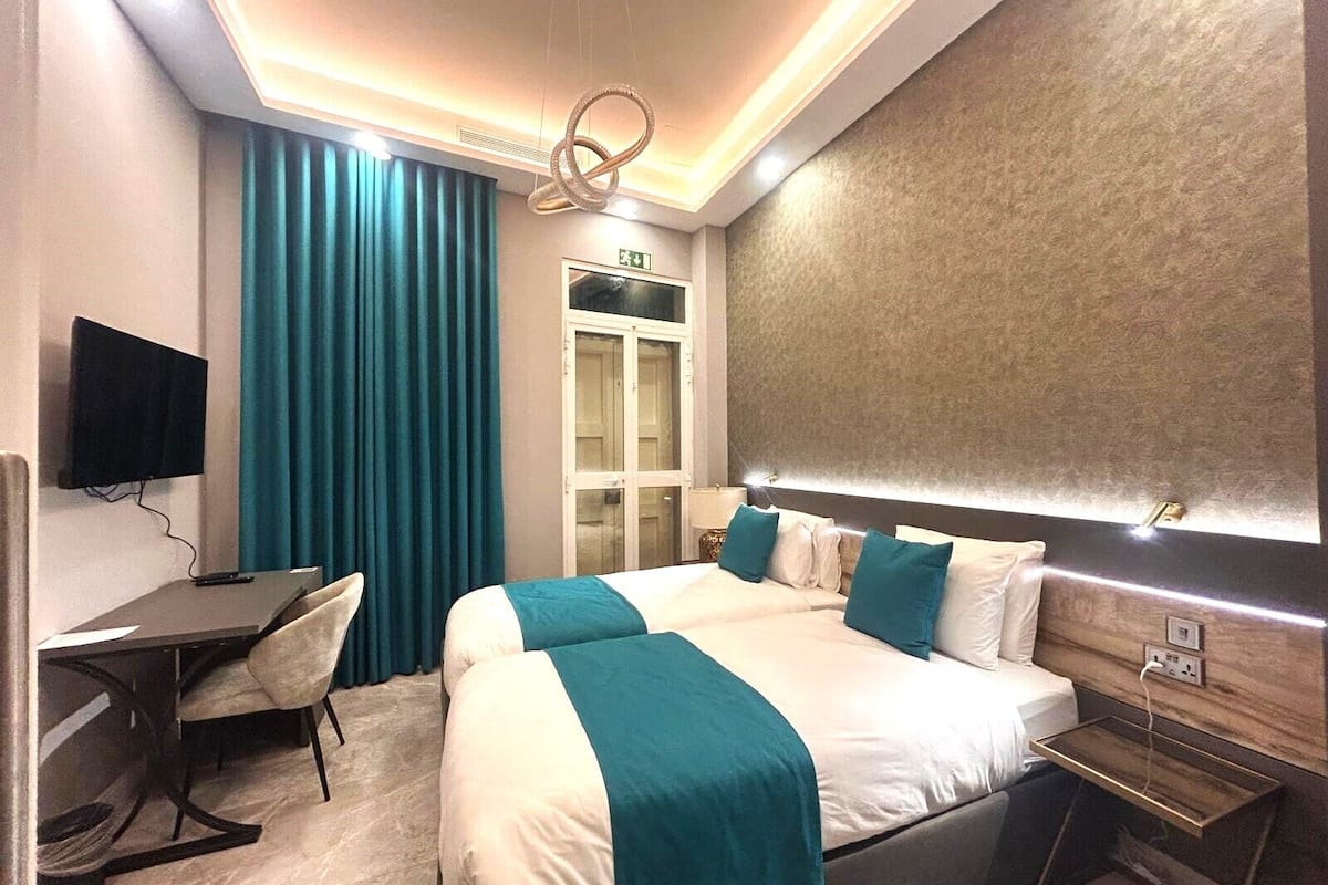 A modern hotel room with a large bed, a desk, and a television.