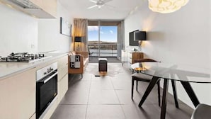 Une cuisine moderne avec un coin repas, un ventilateur de plafond et une vue sur l’extérieur.
