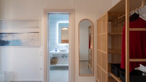 Un bagno moderno con un ampio specchio, un lavandino e una zona doccia.
