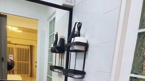 A bathroom with a white sink, a mirror, and a towel rack. - Mana restaurant and boutique hotel (Khon Kaen)