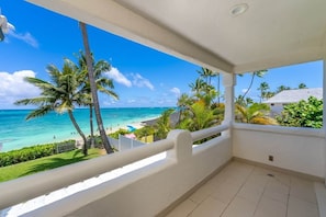 Un balcón con vista a la playa y al océano.