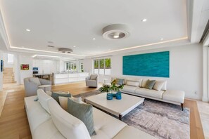 Ein modernes Wohnzimmer mit einem weißen Sofa, einem Couchtisch und einem großen abstrakten Gemälde an der Wand.