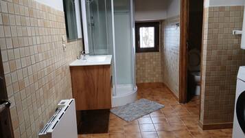 Een badkamer met een douche, wastafel en toilet.