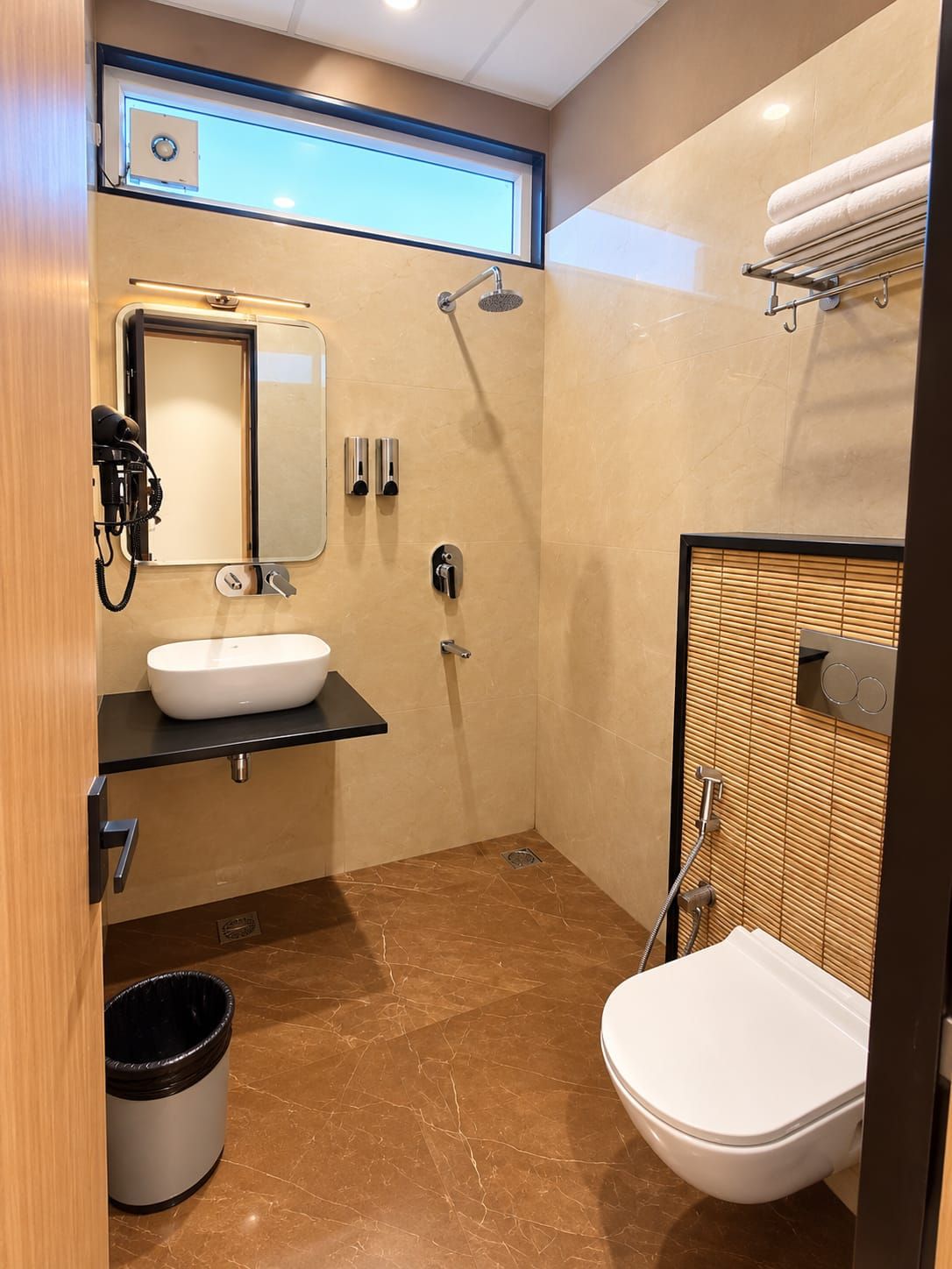 A compact bathroom with a sink, mirror, shower, and toilet.