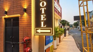 A hotel sign with an arrow pointing left, indicating the direction to the hotel entrance.
