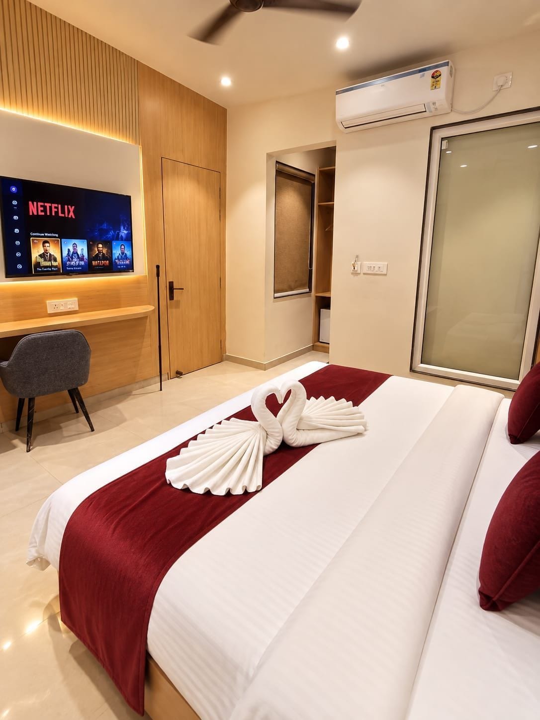 Ein Hotelzimmer mit einem Bett, einem Schreibtisch, einem Fernseher, der Netflix-Inhalte anzeigt, und einem Kleiderschrank.