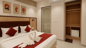 Une chambre d’hôtel avec un grand lit, une armoire et un petit réfrigérateur.
