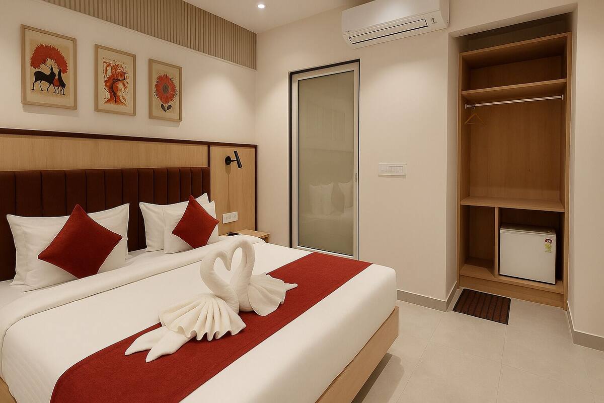 Una habitación de hotel con una cama grande, un armario y un refrigerador pequeño.