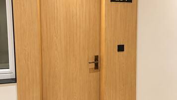A wooden elevator door with a number plate '204' and a light fixture above it.
