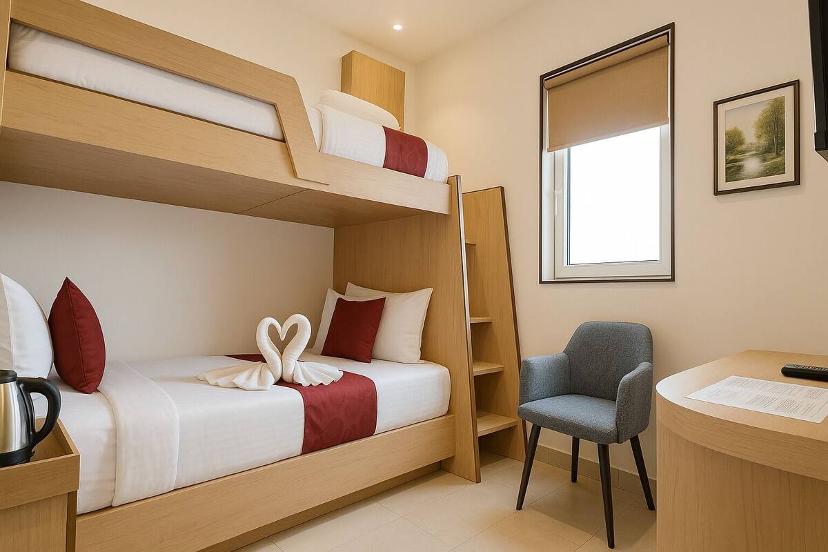 Habitación con literas, escritorio, silla, un cuadro en la pared y ventana con vistas.