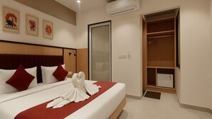 Una habitación de hotel con una cama bien hecha, un armario y un espejo grande.