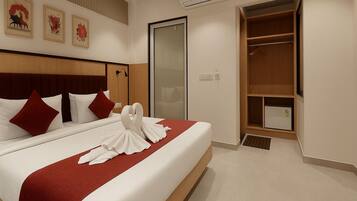 A hotel room with a neatly made bed, a wardrobe, and a large mirror.