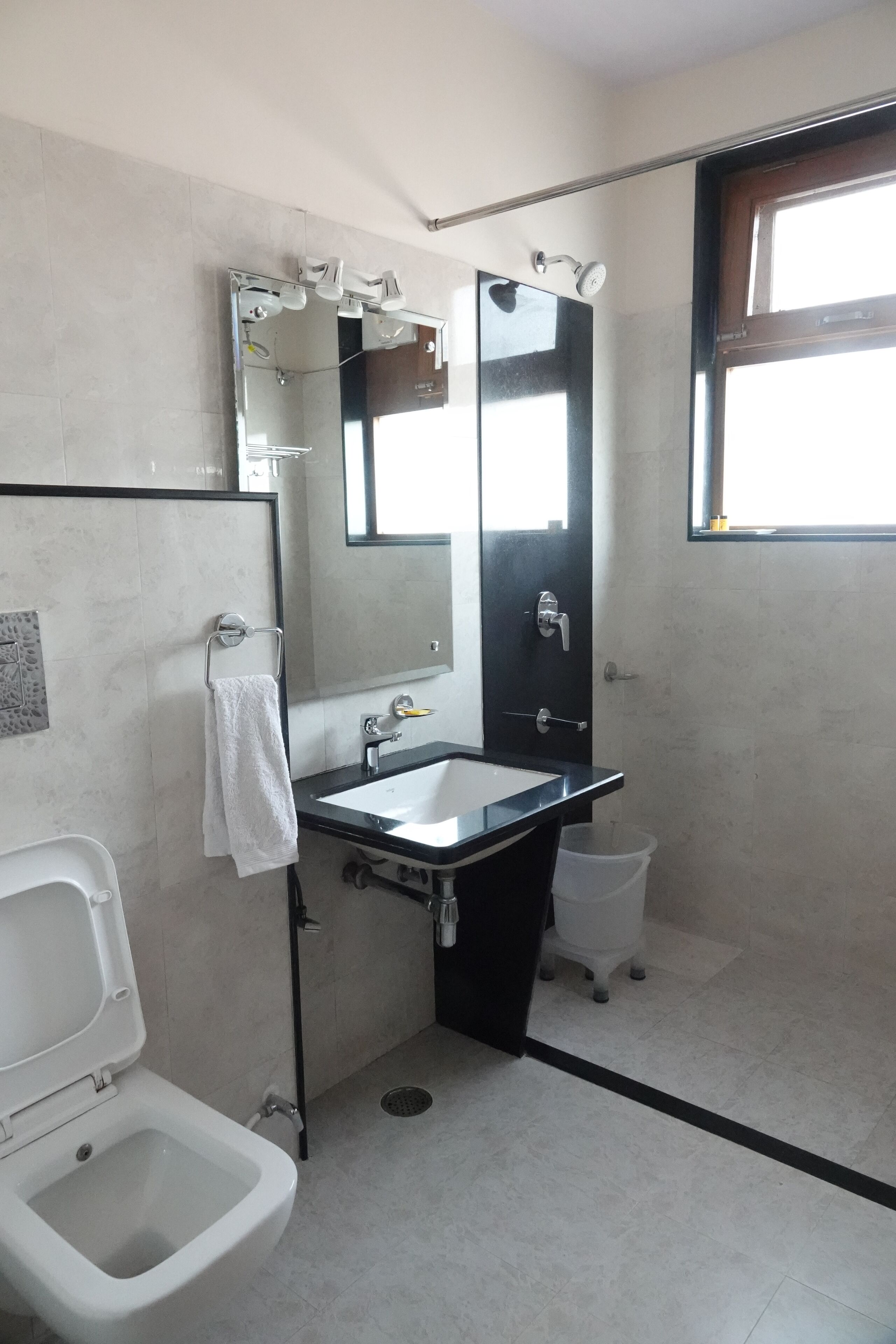 Une salle de bain équipée de toilettes, d’un bidet, d’un lavabo et d’un miroir.