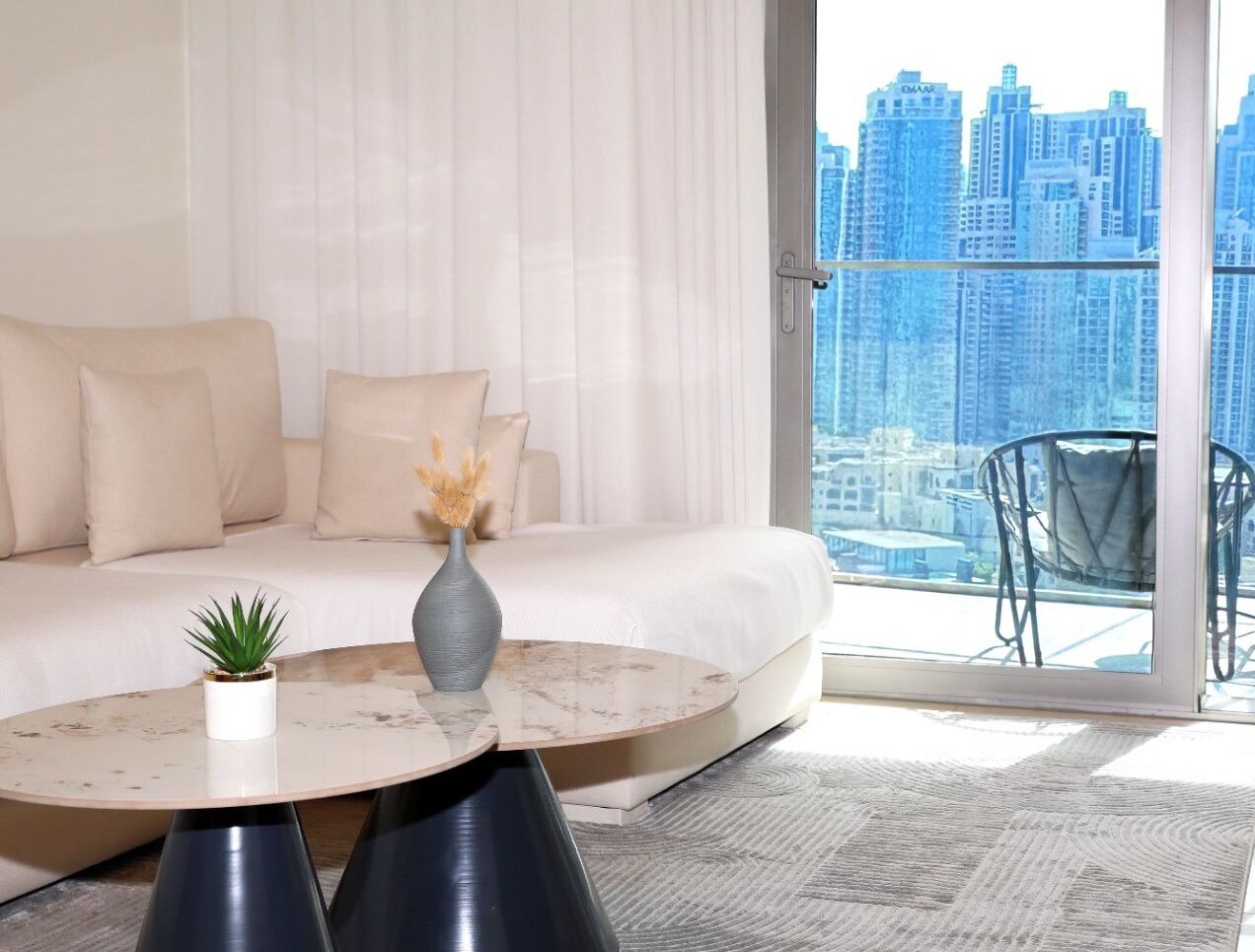 A modern living room with a sofa, a round coffee table, and a potted plant.