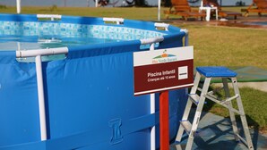 A blue inflatable pool with a sign indicating it is for children under 10 years old.