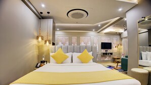 Une chambre d’hôtel avec un grand lit, une télévision, un bureau et un miroir.