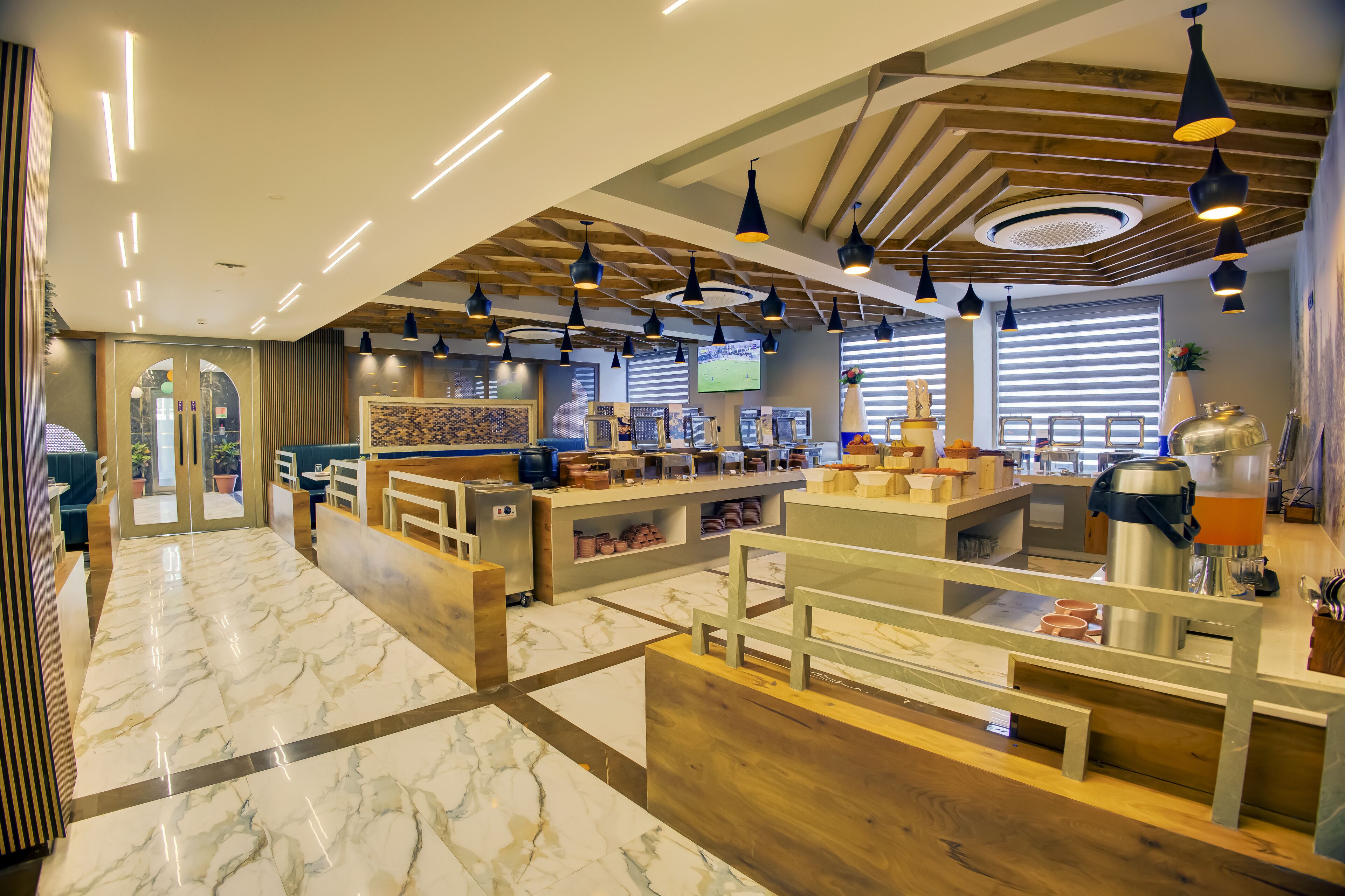 A modern hotel lobby with marble flooring, wooden accents, and multiple seating areas.