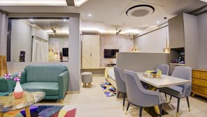 Un salon moderne comprenant un canapé, une table basse et un coin repas avec des chaises et une table.