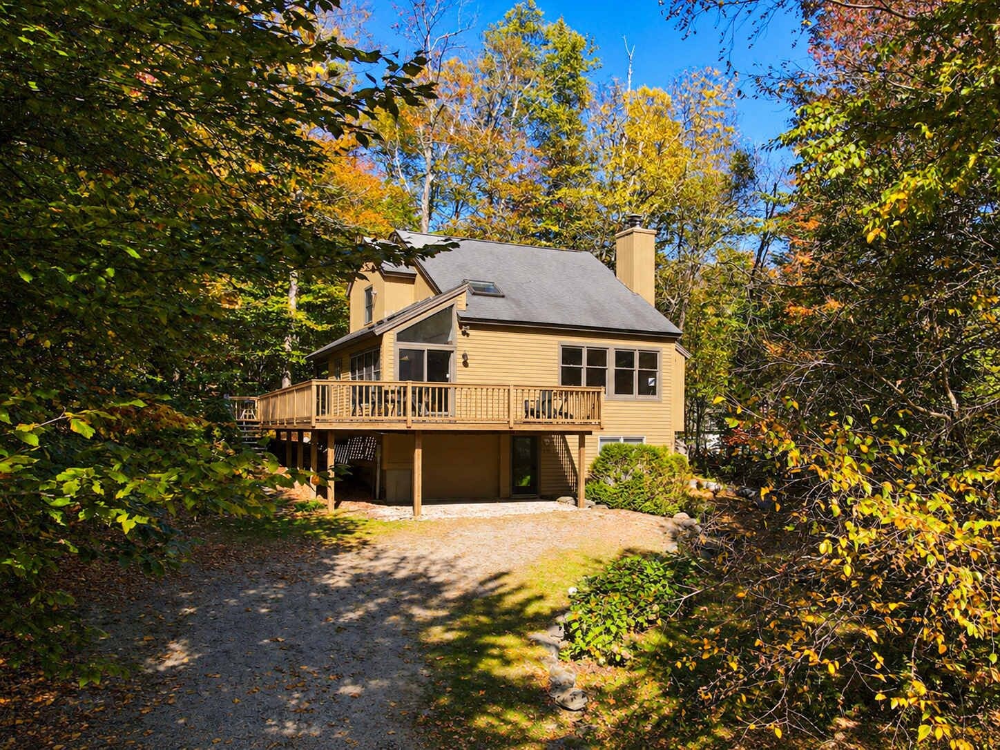 A two-story house with a covered porch and a chimney.