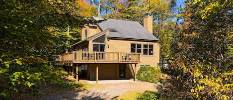 A two-story house with a covered porch and a chimney.