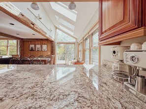 Una cocina amplia con una encimera de granito, armarios de madera y una estufa empotrada.