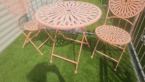 A balcony with a round table and four chairs, surrounded by a metal railing. - Spacious 6 berth caravan with decking. Indoor Heated pool on site!! (Burnham-on-Sea)