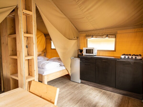 A compact, tent-style accommodation with a bed, kitchenette, and a small table. - Terrace Apartment With Forest (Manhay)