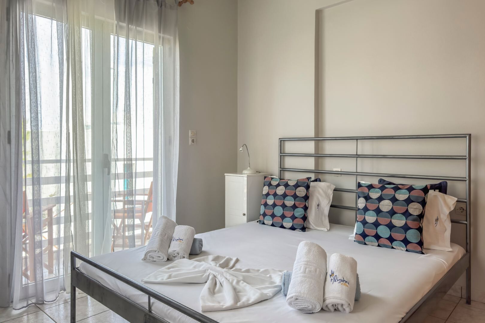 A hotel room with a bed, pillows, and towels.